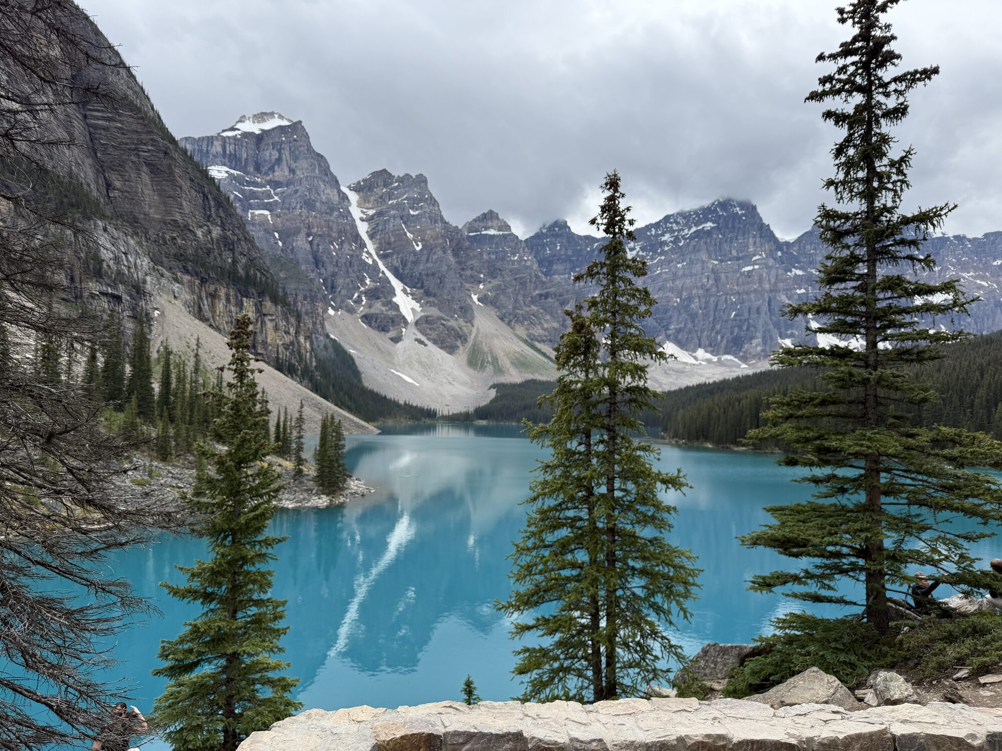 A turquoise alpine lake beneath dramatic mountains